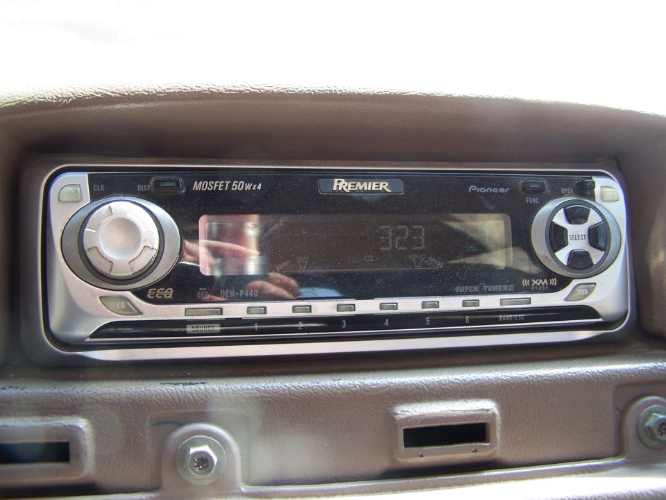 Pioneer Premier car stereo system with digital display and controls installed in a vehicle dashboard.