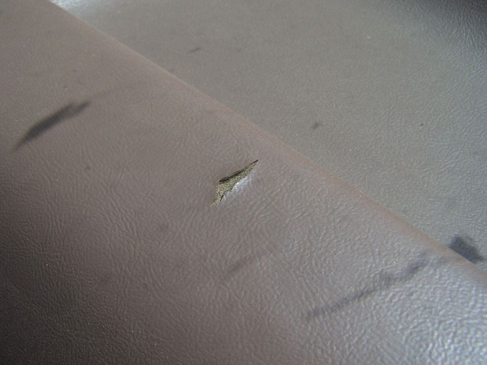 Close-up of a tear in brown vinyl interior of a 1994 Ford Bronco.