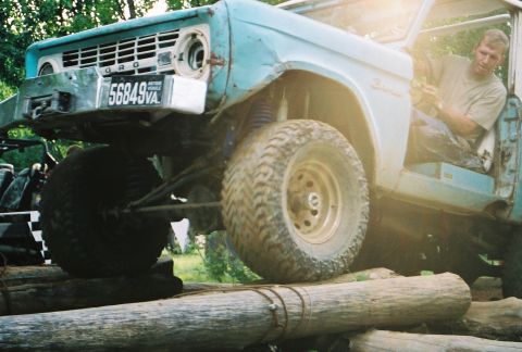 1991 Ford Bronco - This classic Ford Bronco is positioned on logs, its off-road capabilities and vintage design.