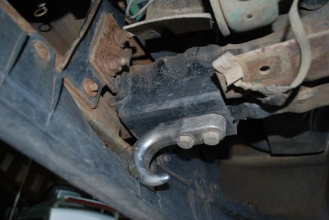 1996 Ford Bronco - A close-up view of a silver tow hook attached to a black bracket on a vehicle's undercarriage. The hook is secured with two large bolts and…