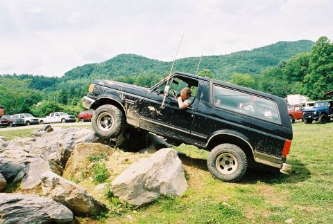 1991 Ford Bronco - A black Ford Bronco maneuvers through a challenging rock obstacle course.