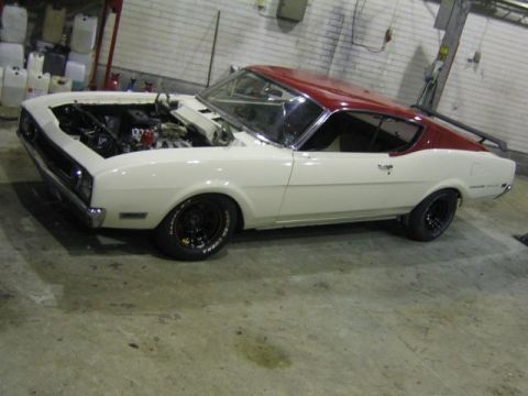 1969 Mercury Cyclone - A 1969 Mercury Cyclone coupe in white with a red roof is shown with its hood open, parked indoors.