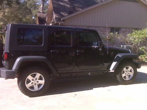 2008 Jeep Wrangler - Side view of a black Jeep Wrangler, likely a 2007 model, parked in front of a residential building.