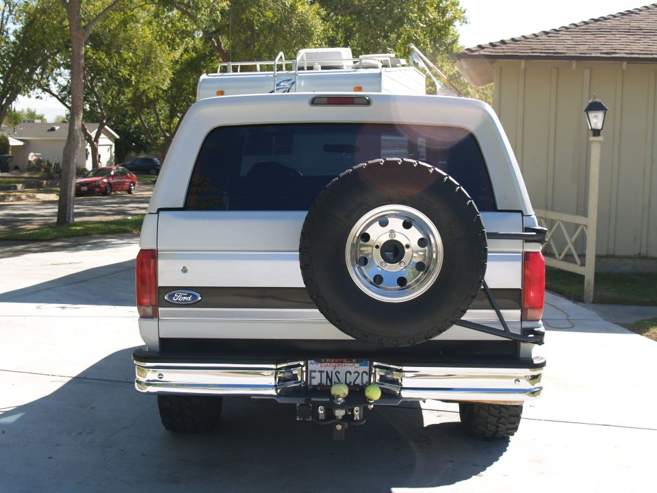 Rear view of a silver 1993 Ford Bronco with a spare tire and chrome bumper