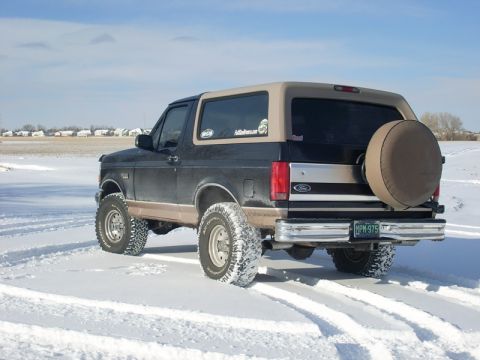 1996 Ford Bronco - 1996 Ford Bronco seen in a snowy field with tire tracks.