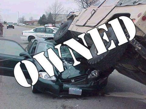 1972 Ford Ranchero - A car crash scene shows a green car severely damaged under a military vehicle, with a police car nearby.