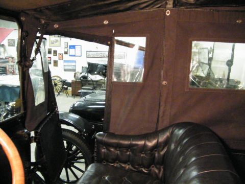 1915 Ford Model T - Looking inside a classic car, showing the tufted leather seats and the fabric roof with windows.