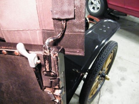 1915 Ford Model T - Close-up of a 1915 Ford Model T showing interior details and a spoked wheel, with another vehicle visible in the background.
