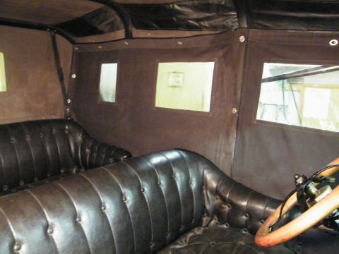 1915 Ford Model T - Interior view of a 1915 Ford Model T, showing the tufted leather seats and side curtains.