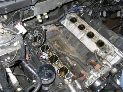 2007 Ford Mustang - Close-up view of a disassembled engine bay, revealing internal components and wiring harnesses.