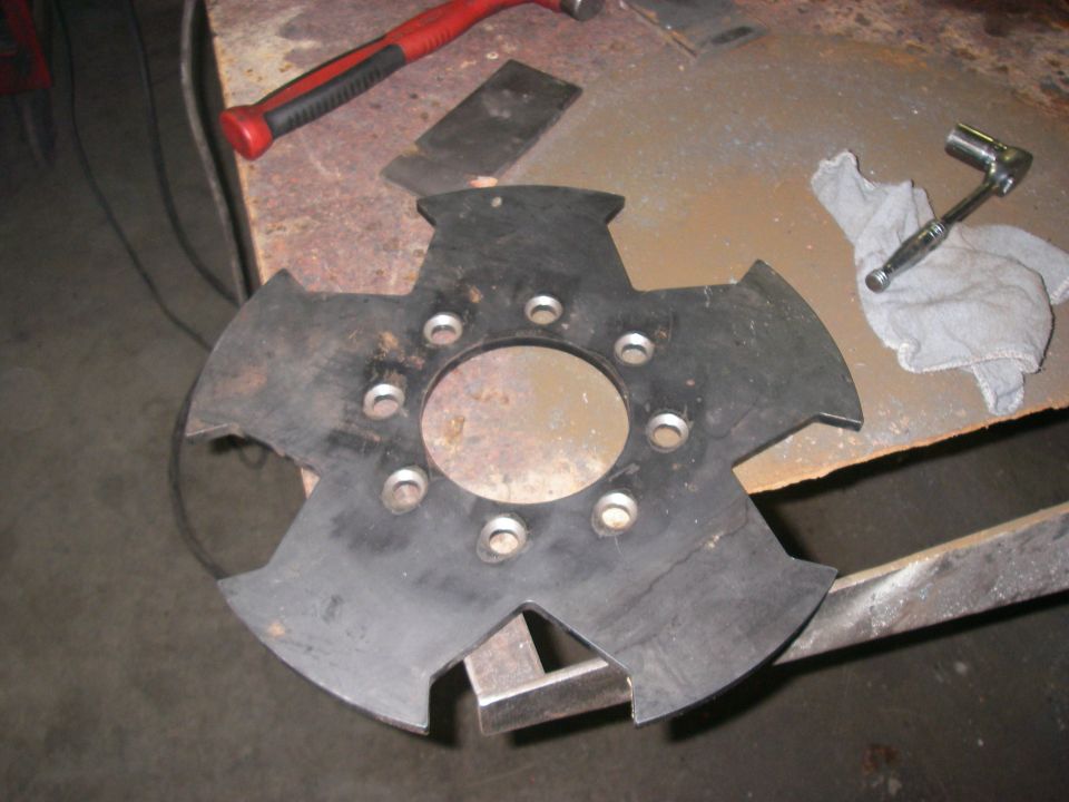 Black multi-finger clutch disc lying on a metal workbench