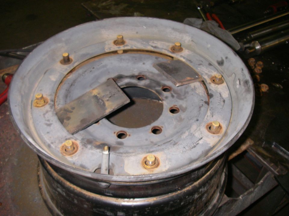 Modified wheel rim with welded metal plates and lug nuts