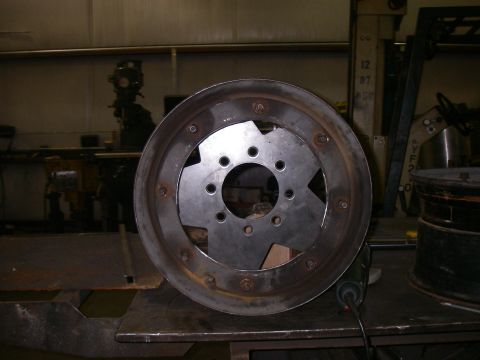 1978 Ford Bronco - A close-up view of a modified wheel rim with a central metal adapter plate.