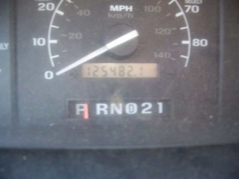 Close-up of a vehicle's dashboard showing the odometer reading 125482.1 and the gear selector in 'R' (Reverse)