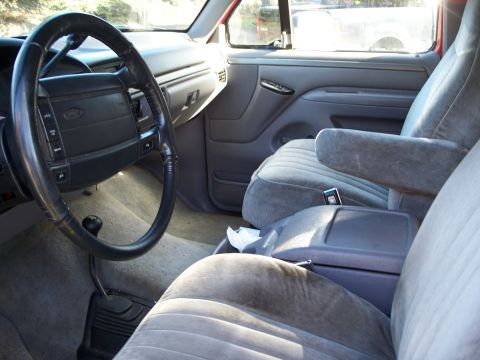 1977 Ford F-150 - The interior of a truck shows gray seats, a dashboard, and a steering wheel.