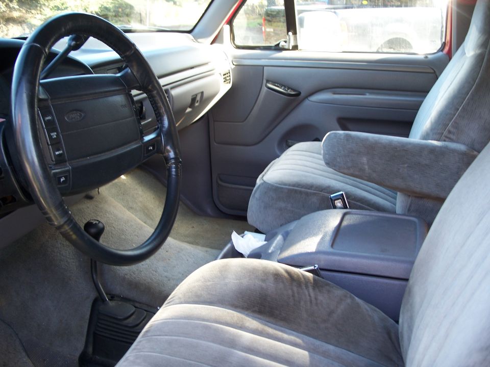 Gray fabric seats and dashboard of a truck interior, with a black steering wheel and center console