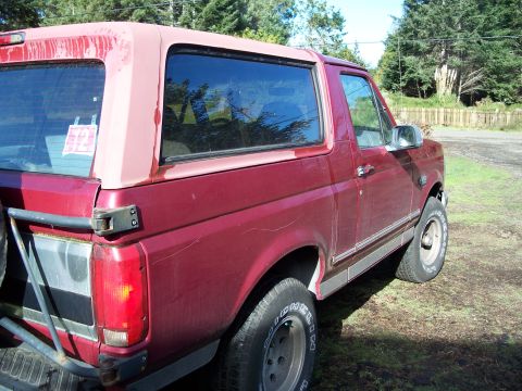 1977 Ford F-150 - This red SUV features a removable top and is shown from the rear quarter angle.