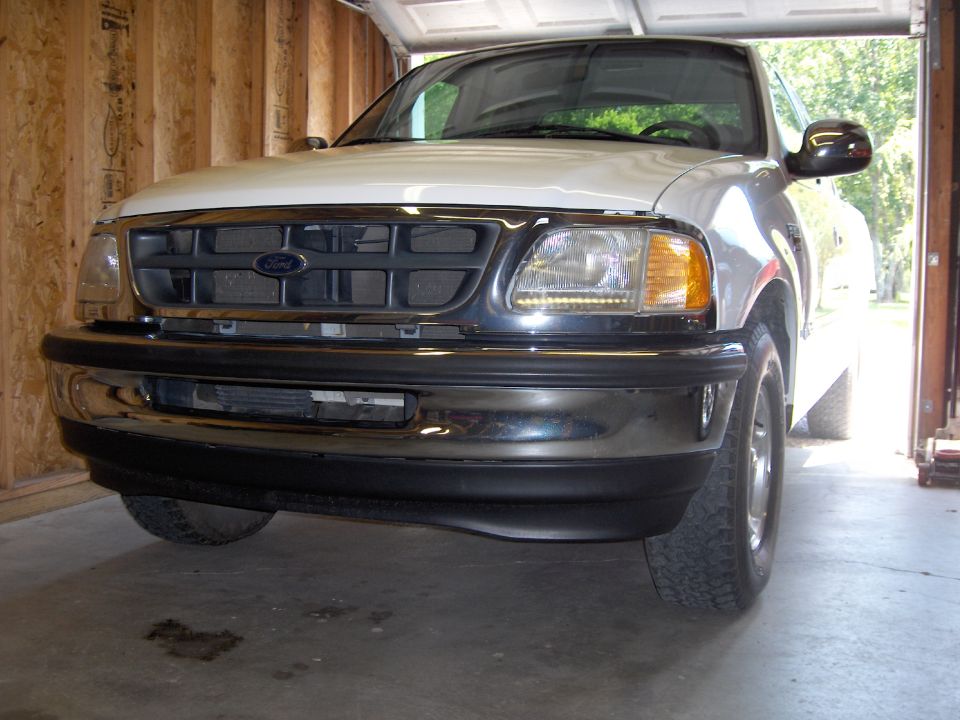 Front view of a white Ford F-150 pickup truck with a chrome grille and bumper