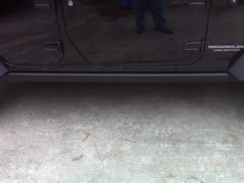 2008 Jeep Wrangler - Close-up of the side of a black Jeep Wrangler Unlimited, highlighting the rock rail and door panel.