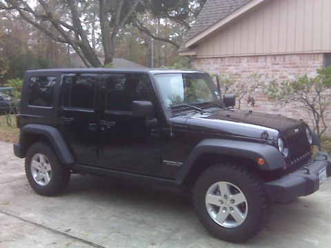 2008 Jeep Wrangler - A black Jeep Wrangler is parked outside a brick house.