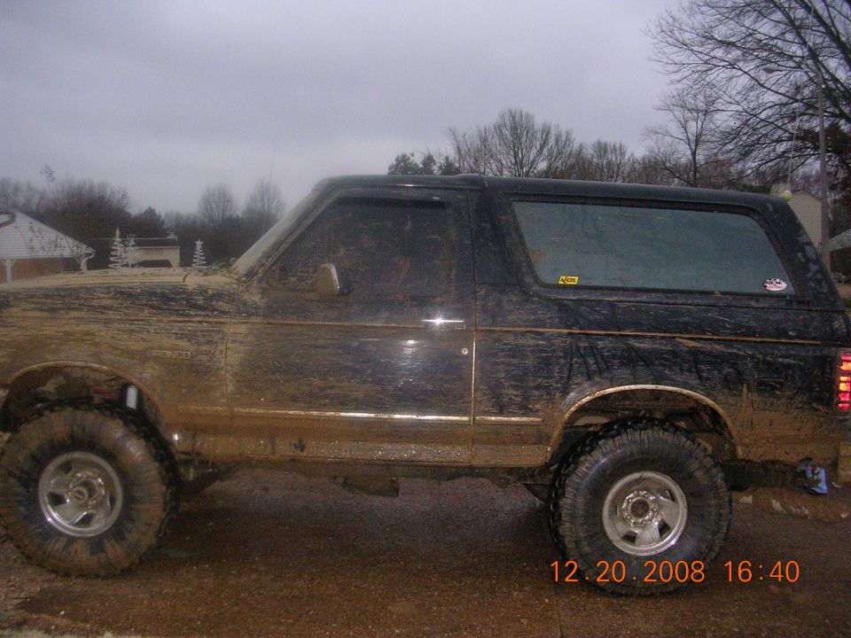 1994 Ford Bronco covered in mud, side view