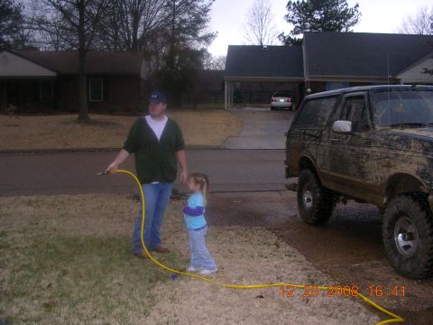 1994 Ford Bronco - A man and a young girl stand in a yard next to a very muddy SUV.