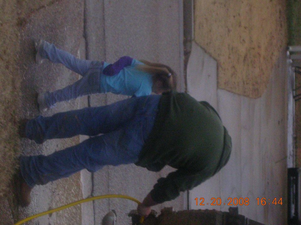 People working on a vehicle with a timestamp of 12.20.2008 16:44