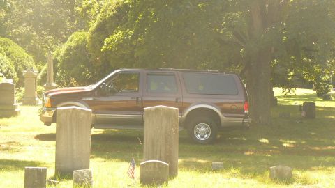 2000 Ford Excursion - A Ford Excursion is parked among gravestones in a cemetery on a sunny day.