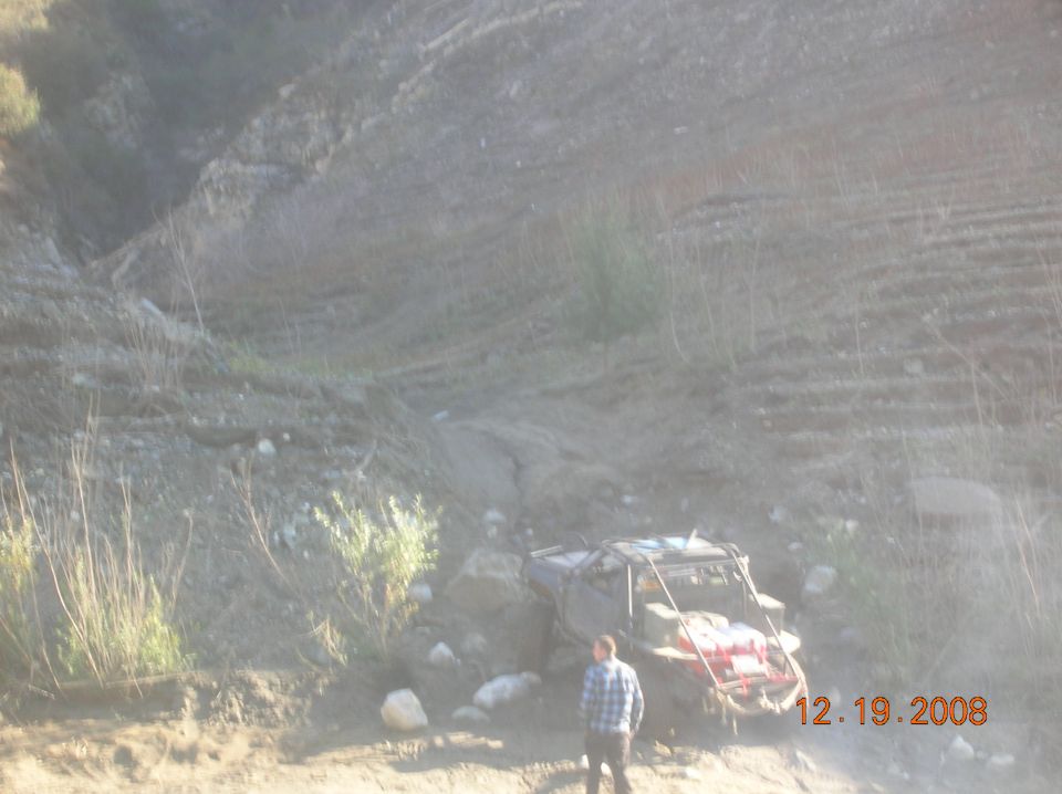 Off-road buggy with a person standing nearby on a dirt hill. Date stamp 12.19.2008