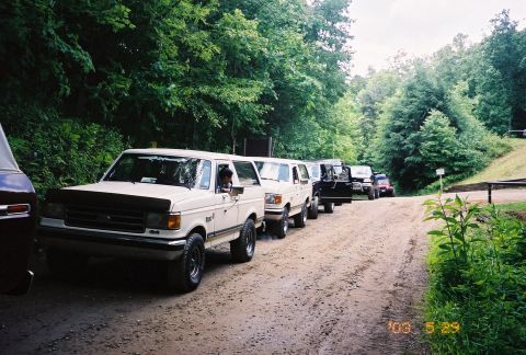 1991 Ford Bronco - Several 1991 Ford Broncos are lined up on a dirt road, ready for an off-road adventure.