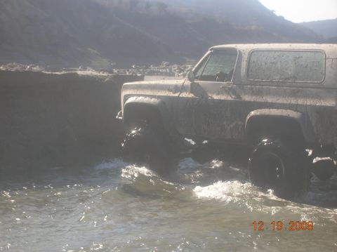 1985 Ford Bronco - Muddy 1985 Ford Bronco navigates through a water crossing.