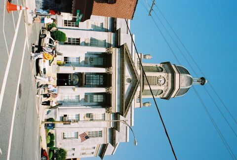 1991 Ford Bronco - A street scene shows a building with a prominent clock tower and several people on the sidewalk.