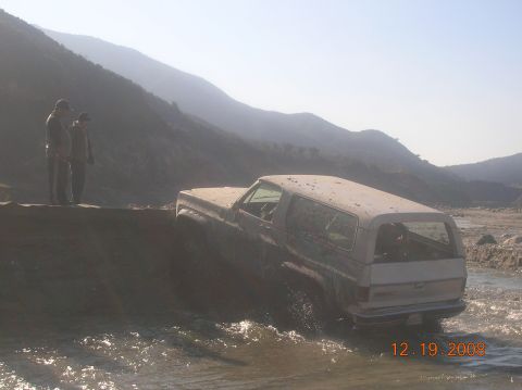 1985 Ford Bronco - This older model SUV appears to be stuck while crossing a shallow body of water.