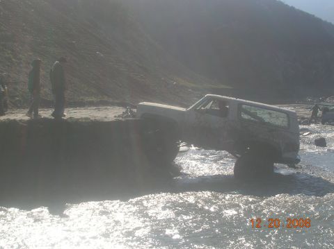 1985 Ford Bronco - This vehicle appears to be stuck in a body of water, with two people observing from the bank.