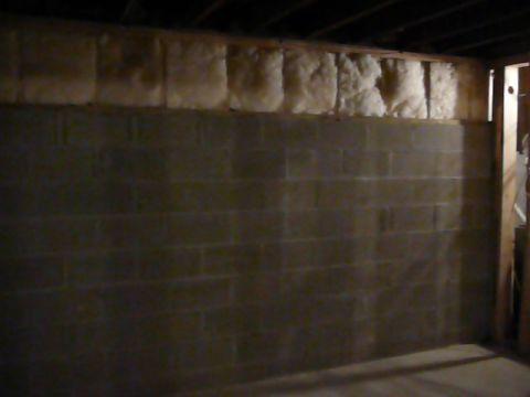 1997 Mercury Grand Marquis - This image shows the interior of a basement with unfinished walls. The walls are made of concrete blocks and insulation is visible near the…