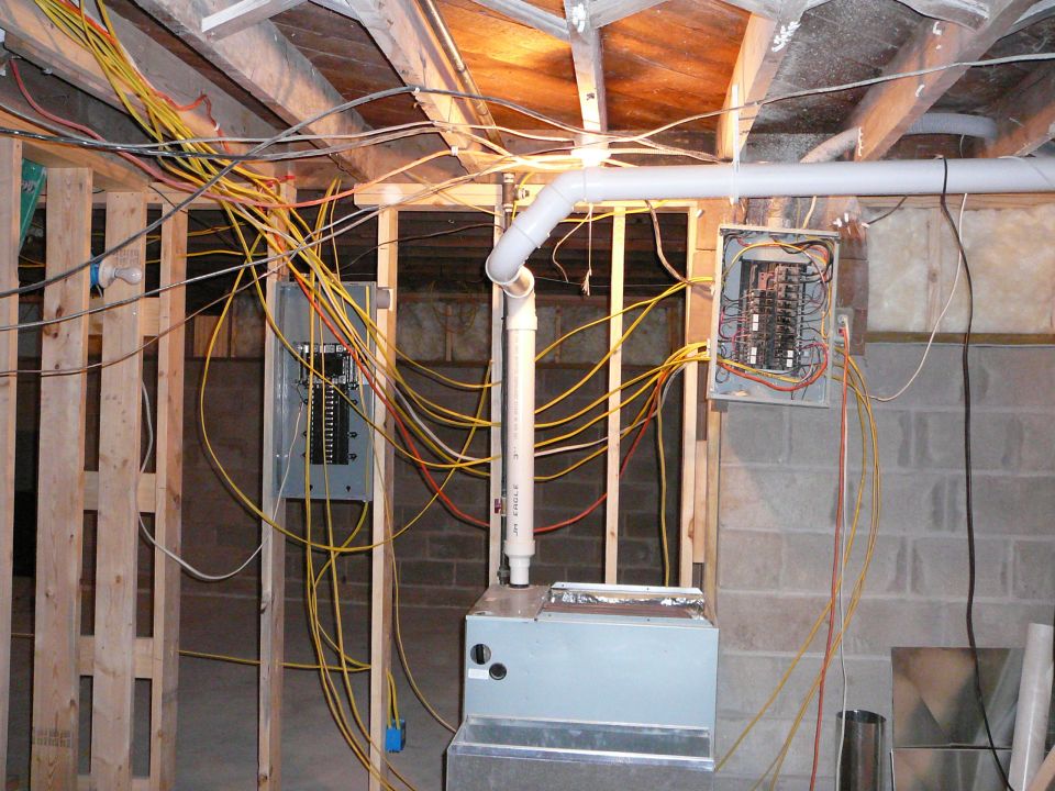 Interior framing of a house under construction, showing wooden studs and ceiling joists