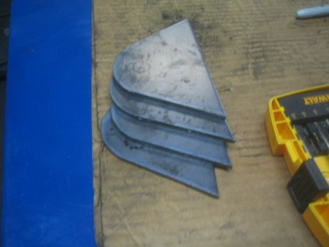 1990 Ford Bronco - Photograph of cut sheet-metal pieces on a workbench, not a technical document.