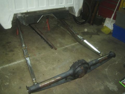 1990 Ford Bronco - Photograph of a rear axle and frame assembly on jack stands, not a technical document.