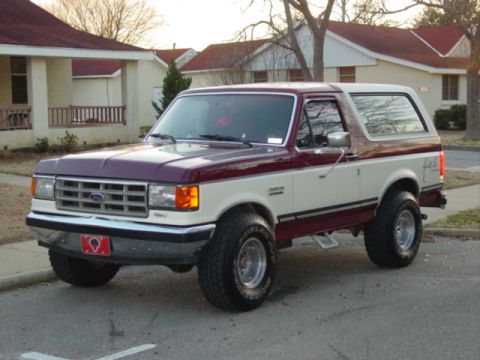 1988 Ford Bronco - This two-tone Ford Bronco is parked in front of a residential building.