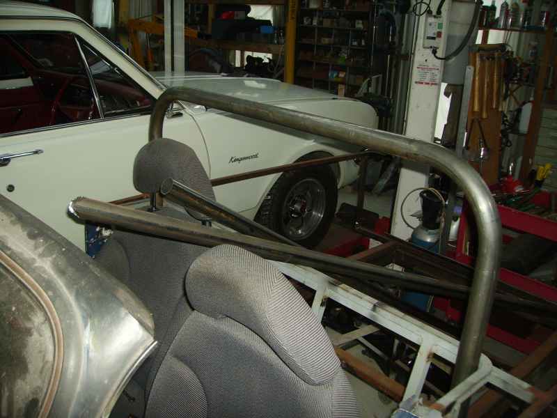 roll cage and seats inside a car being worked on in a garage