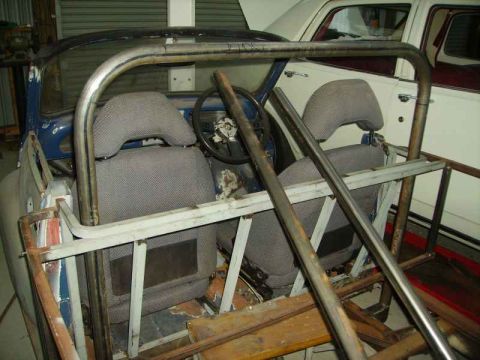 1969 MINI Cooper - The interior of a car, likely undergoing modification, is visible with a prominent roll cage structure.
