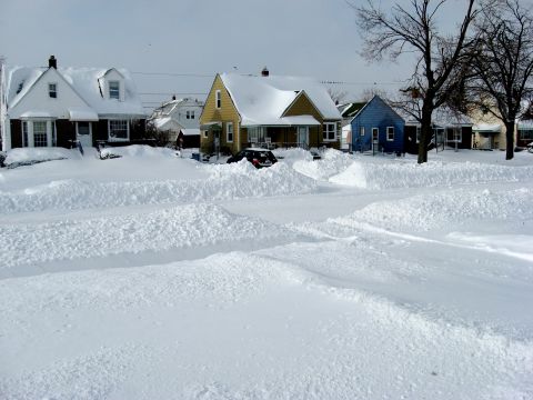 1975 Ford Torino - A red car is visible in a snowy residential area with houses covered in snow.