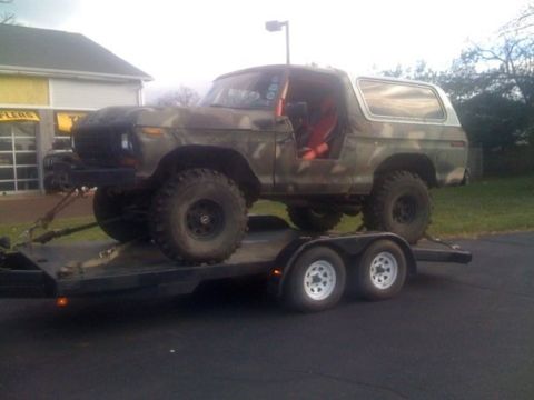1979 Ford Bronco - This lifted Ford Bronco, likely from the late 1970s, is being transported on a flatbed trailer.