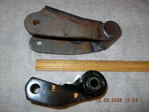 1997 Ford F-250 - Comparison of two suspension parts, one raw metal and one black, with a wooden ruler.