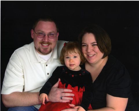 2000 Ford Crown Victoria - A family poses for a portrait, with the father holding the child.