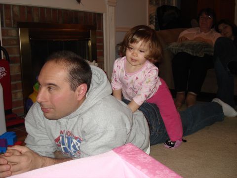 2000 Ford Crown Victoria - A man and child interact on the floor while two women watch from a couch.