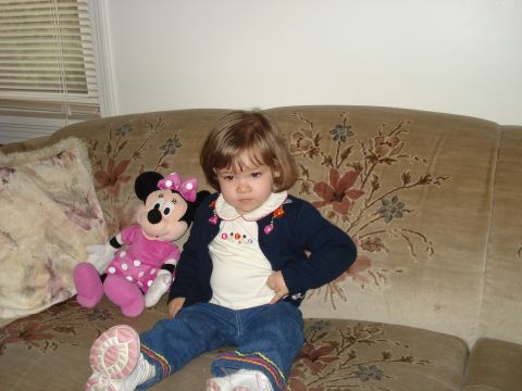 2000 Ford Crown Victoria - A child and a stuffed toy are seated on a patterned sofa.