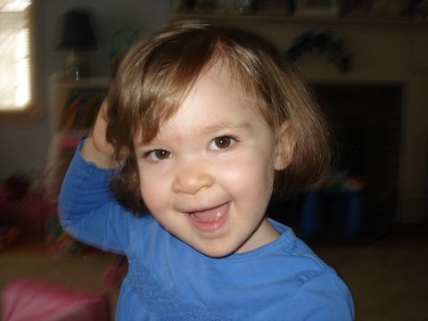 2000 Ford Crown Victoria - A young child with brown hair smiles widely while looking at the camera.