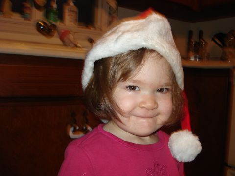 2000 Ford Crown Victoria - A young child wears a Santa hat and smiles for the camera.