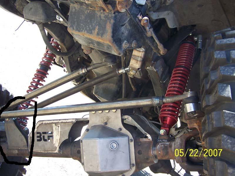 Off-road vehicle suspension with red shocks, metal linkages, and BCF logo.